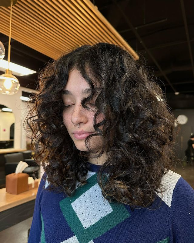 7. Curly Wolf Cut with Face-Framing Layers by @beautyyybybrenon ig. This style works beautifully on naturally curly hair. The wolf cut's layers enhance the natural curl pattern, while face-framing layers add a touch of softness and definition.